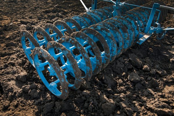 harrow on a background of plowed soil preparing the field for sowing.